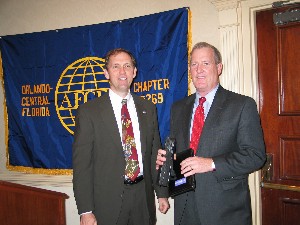Dr. Roger Smith, chapter president (l), presents a token of appreciation to Rear Adm. Timothy L. Heely, USN (Ret.), president, SPARTA Incorporated, who served as the featured speaker during the February meeting.